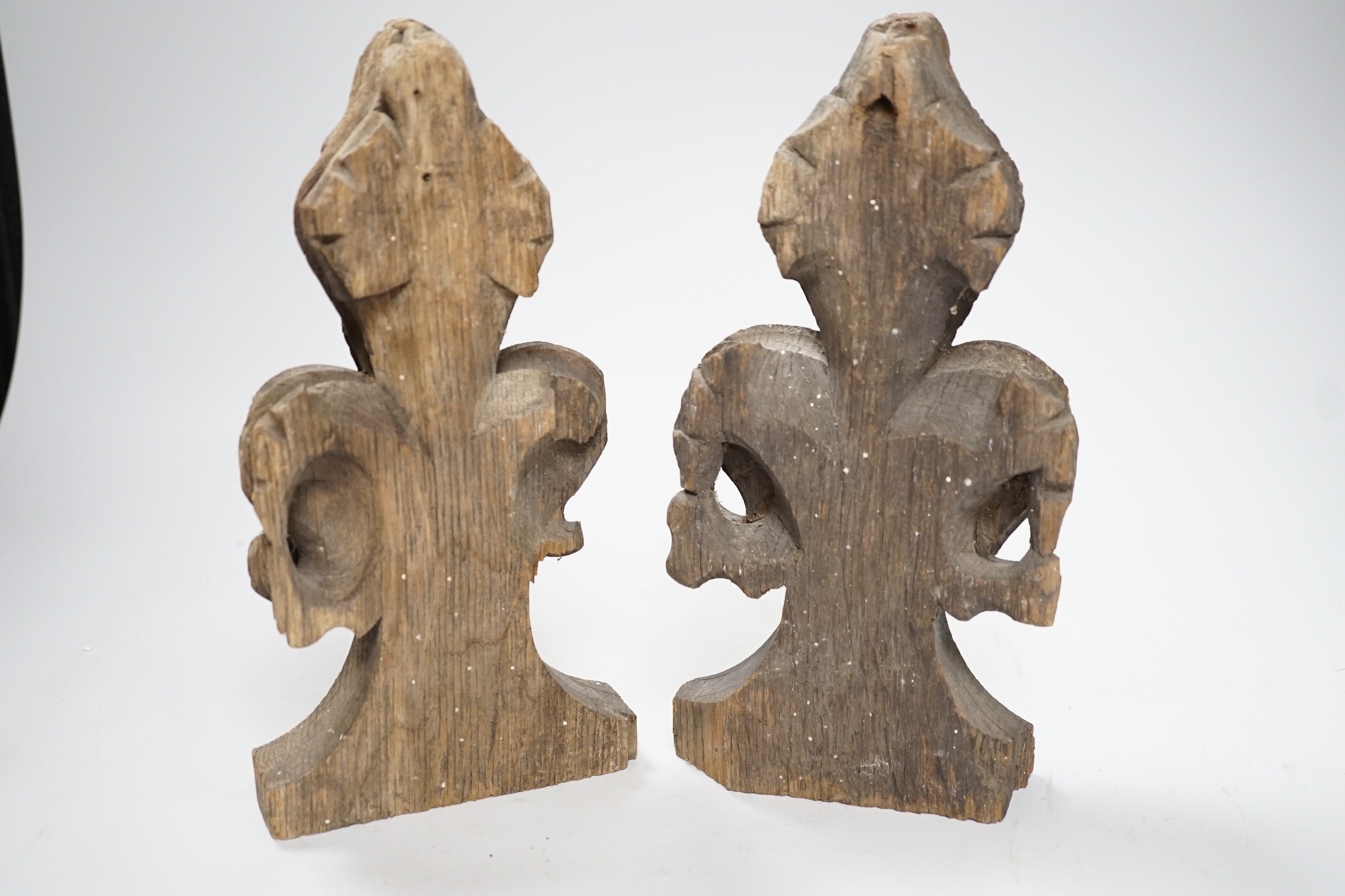 A pair of 16th century oak fleur de lys pew finials, 24cms high